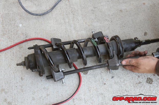 Once the shock is free youll need a spring compressor tool to remove the stock spring from the stock shock. If you dont own this tool, many autopart stores will loan or rent them out, or you can pick up an inexpensive set from Harbor Freight or other retailer.